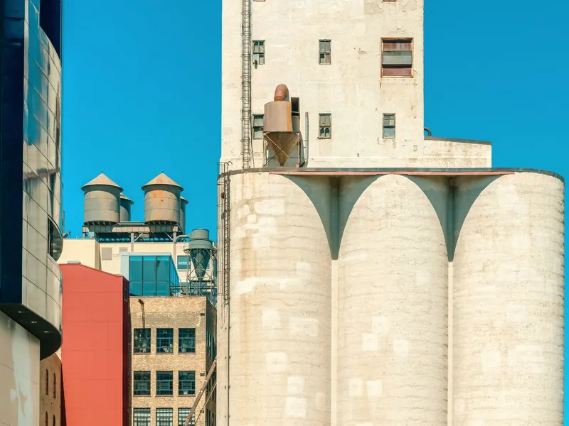 Historic grain mill silos and industrial buildings in Minneapolis beneath a clear blue sky