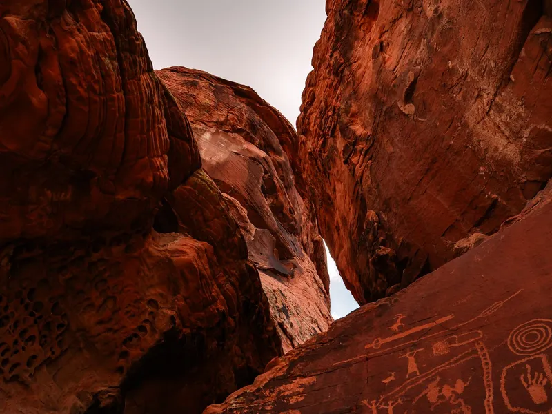 Ancient petroglyphs carved into red sandstone rock in the Nevada desert