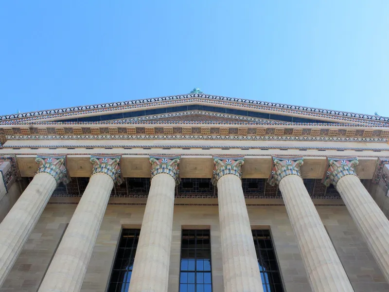 Low-angle view of the Philadelphia Museum of Art columned facade under a clear blue sky