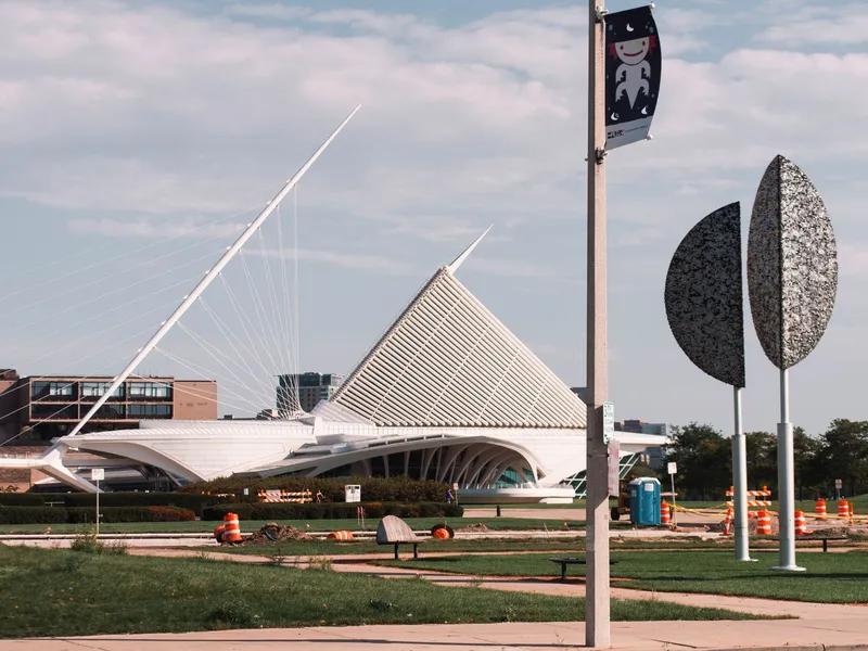 Milwaukee Art Museum's white winged building and cable-stayed mast beside lakefront sculptures in Wisconsin
