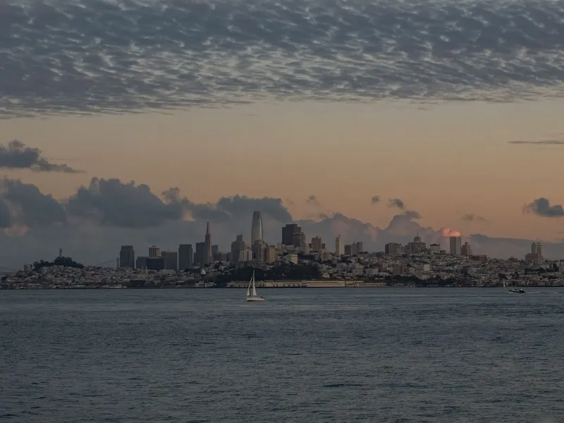 San Francisco skyline across the bay under a dramatic sunset sky