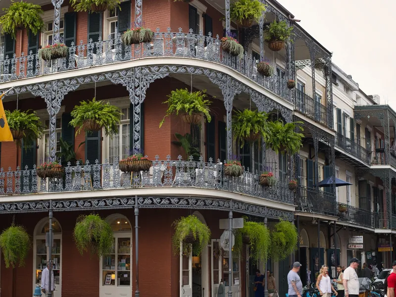Wrought iron balconies hung with ferns on a French Quarter building in New Orleans