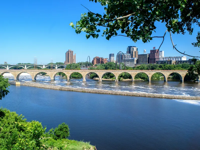 Stone Arch Bridge crossing the Mississippi River in Minneapolis with the downtown skyline beyond