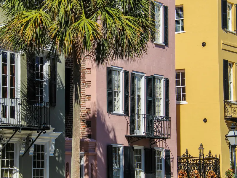 Pastel historic houses and a palm tree on a Charleston, South Carolina street