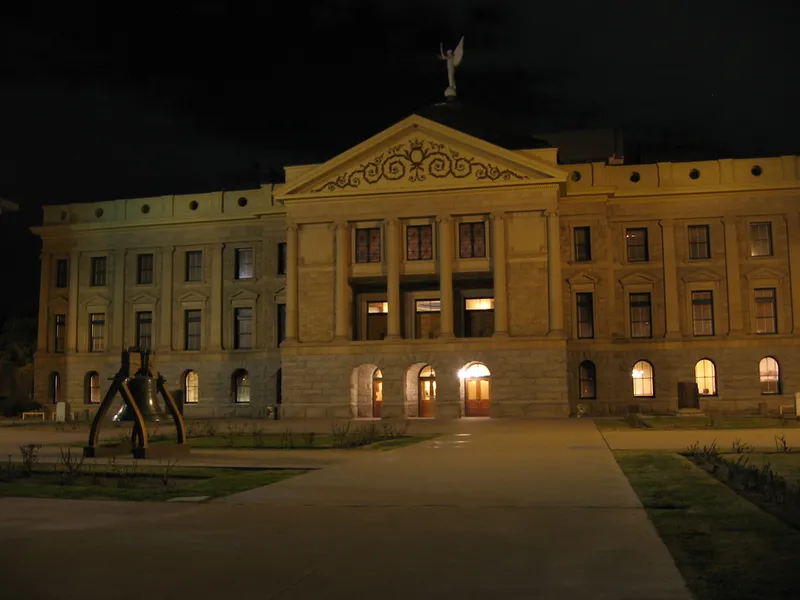 Arizona State Capitol in Phoenix lit at night, with its classical facade and winged statue on the dome