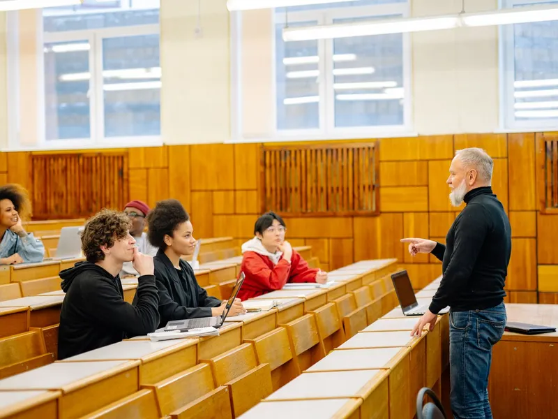 Professor teaching a diverse group of university students seated in a tiered lecture hall
