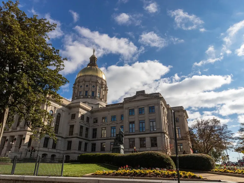Georgia State Capitol with its gold dome beneath a blue sky with scattered clouds in Atlanta