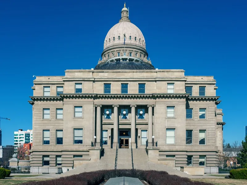 Idaho State Capitol in Boise with its sandstone dome and front steps under a deep blue sky