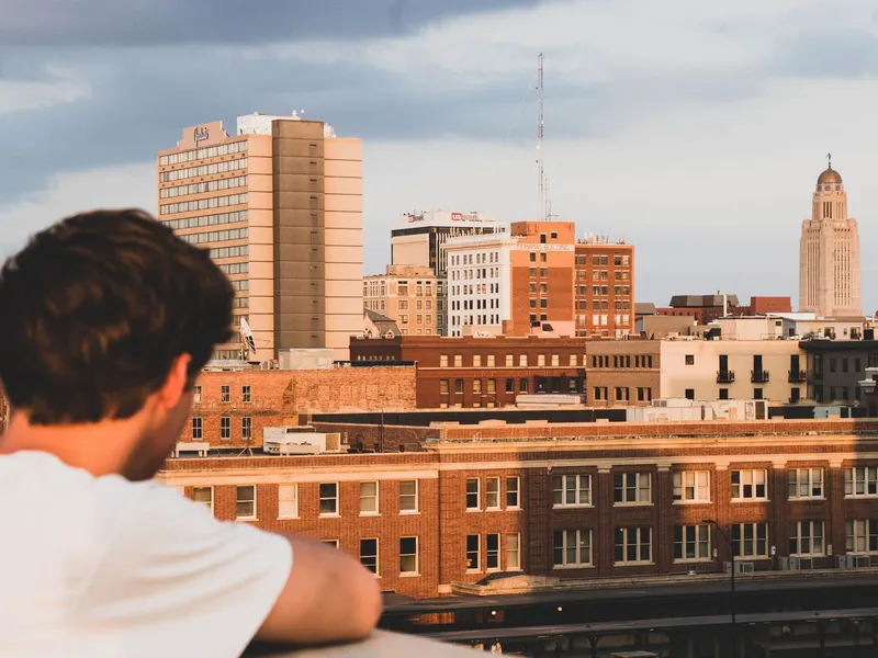 Lincoln, Nebraska skyline at sunset with the State Capitol tower rising above brick buildings
