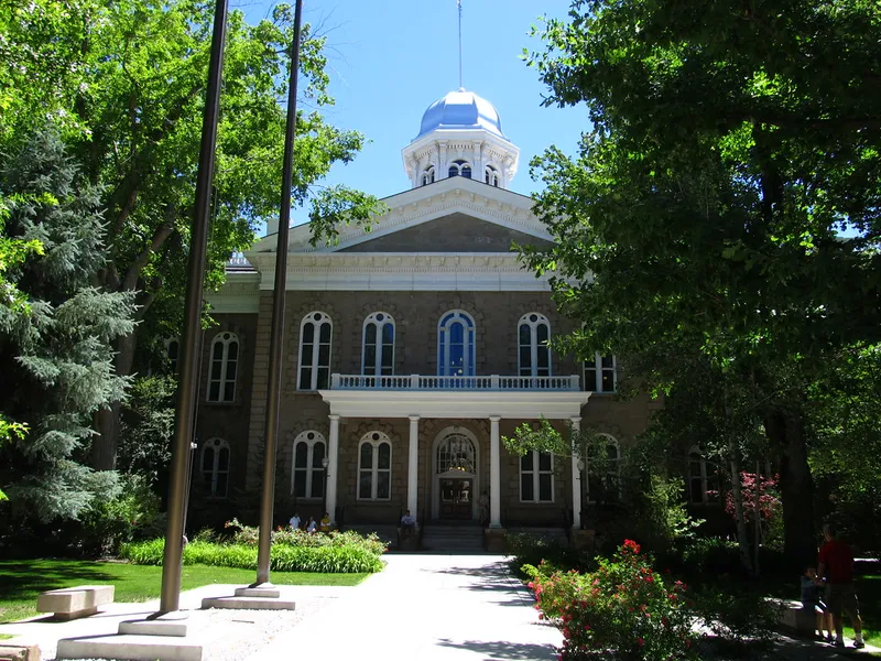Nevada State Capitol in Carson City, a stone building with a silver dome, framed by trees
