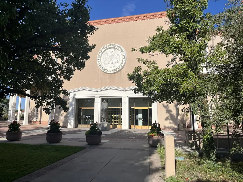 Entrance of the New Mexico State Capitol in Santa Fe with its state seal and flower planters
