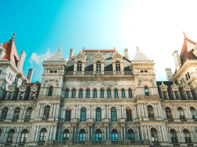 Ornate Renaissance Revival facade of the New York State Capitol in Albany with towers against a blue sky