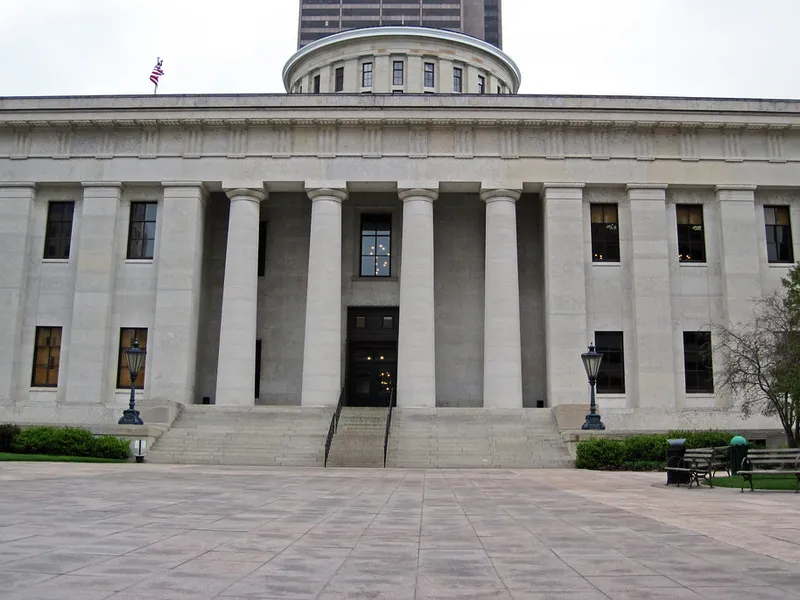 Columned stone facade of the Ohio Statehouse in Columbus with its rotunda rising behind