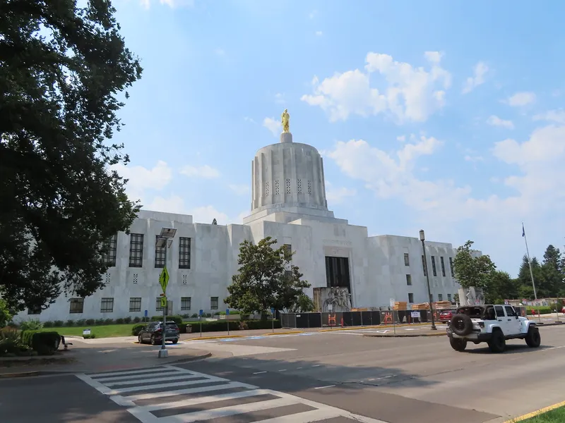 Oregon State Capitol in Salem with its gold pioneer statue atop the tower under a blue sky