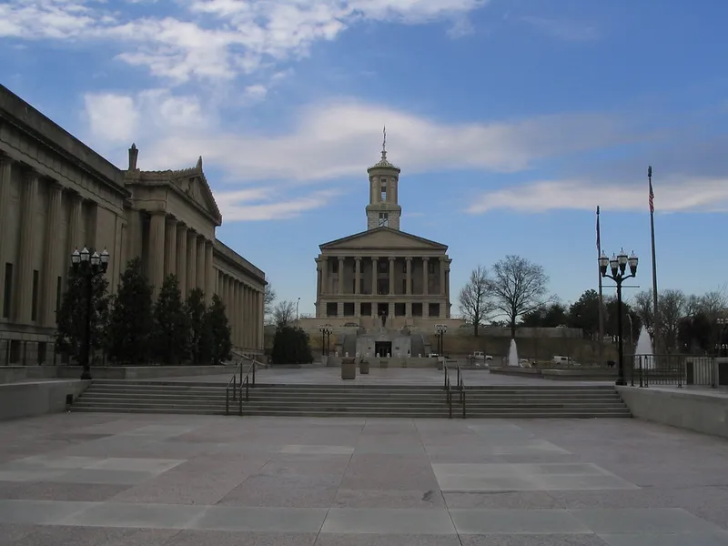 Tennessee State Capitol in Nashville seen across a stone plaza and steps under a blue sky