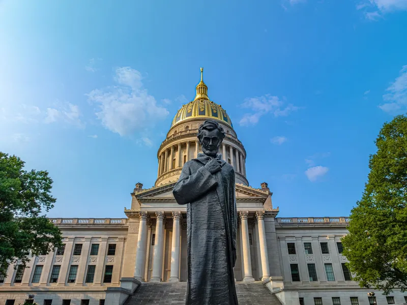 West Virginia State Capitol with its gold dome and a statue of Abraham Lincoln in the foreground