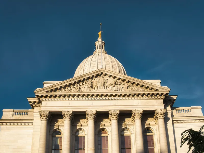 Wisconsin State Capitol in Madison, with its white granite dome, pediment and columns against a deep blue sky