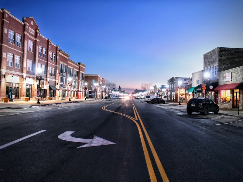 Main Street in Emporia, Kansas at twilight with brick storefronts and glowing street lamps