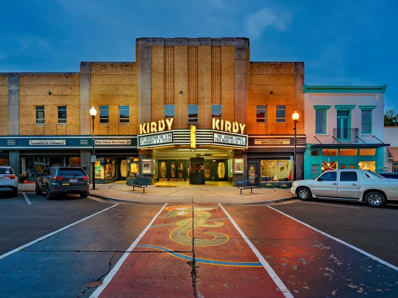Downtown main street of Roxboro, North Carolina at dusk with a lit theater marquee and parked cars