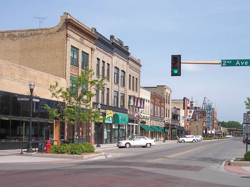 Historic brick storefronts and a street corner in downtown Fargo, North Dakota, on a clear day