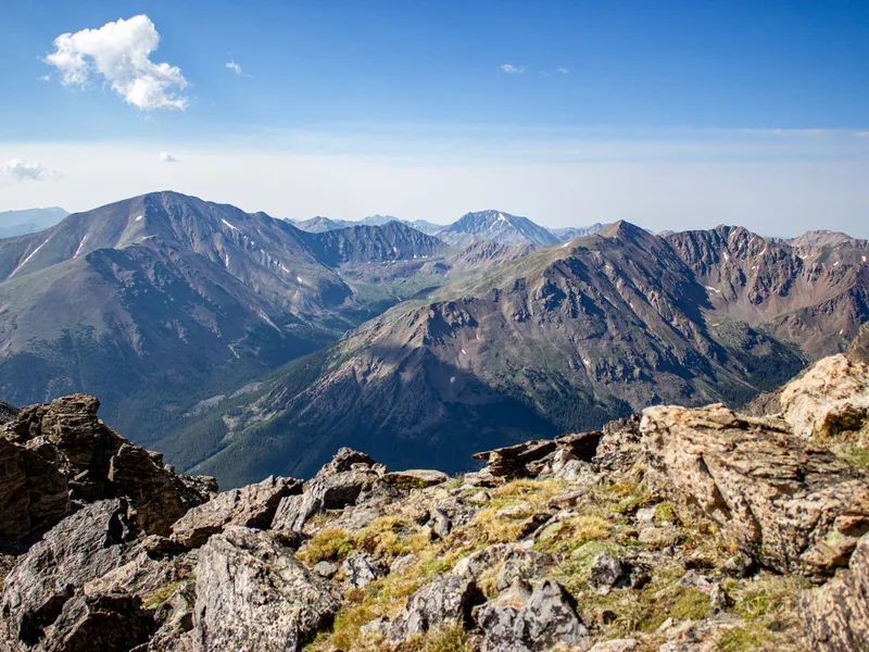 Rocky Mountain peaks and rocky ridgeline under a clear blue sky in Colorado
