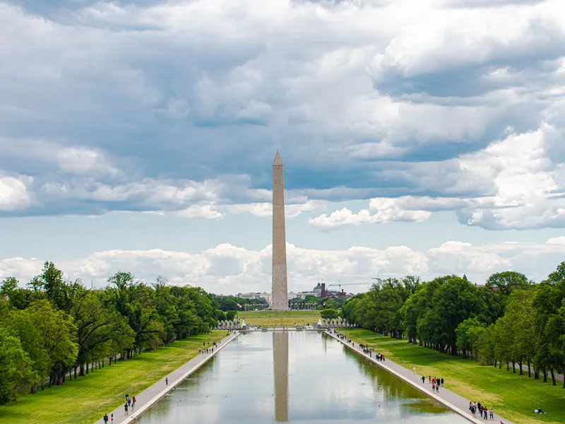 Washington Monument reflected in the Reflecting Pool beneath a cloudy sky in Washington, DC