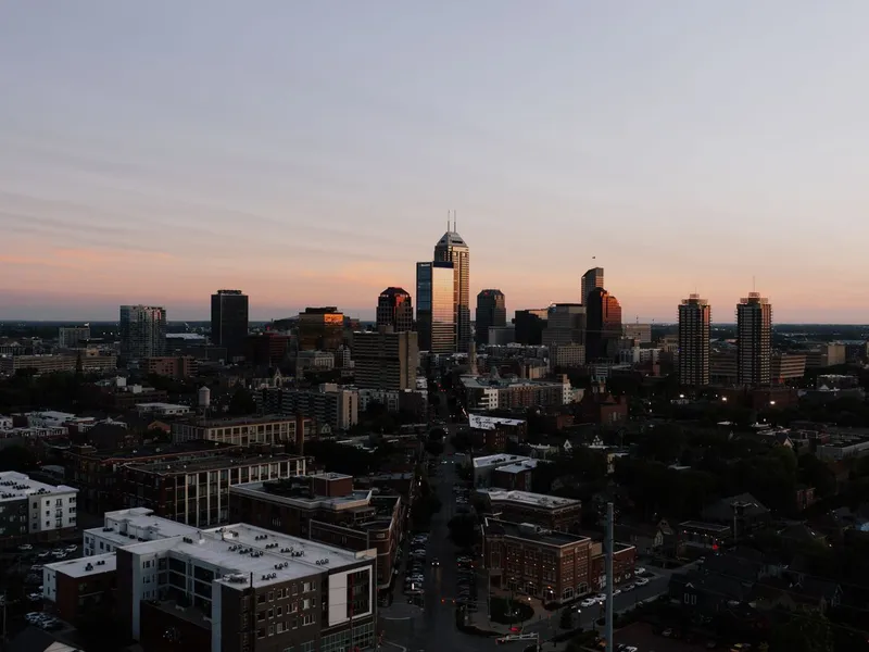 Indianapolis skyline at sunset seen from above, with city streets in the foreground