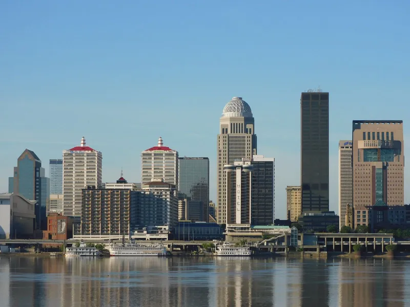 Downtown Louisville skyline reflected in the Ohio River on a clear morning.