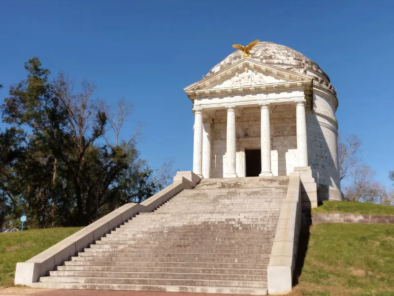 White marble memorial with columns and a gilded eagle atop a hill in Vicksburg National Military Park