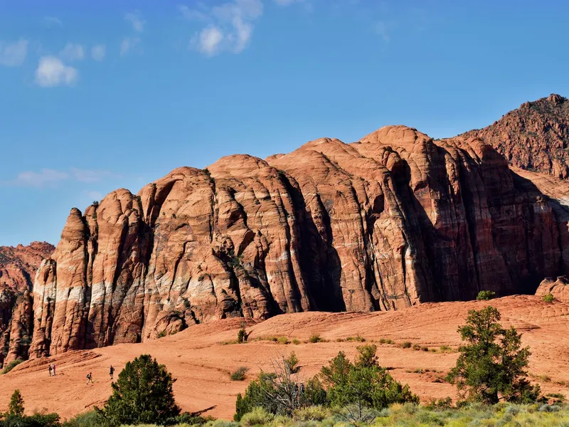 Towering red sandstone formations at Snow Canyon State Park in Utah with hikers on the rock below